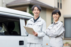 設備業のスタッフがレンタカー車両の前で打ち合わせをしている様子
