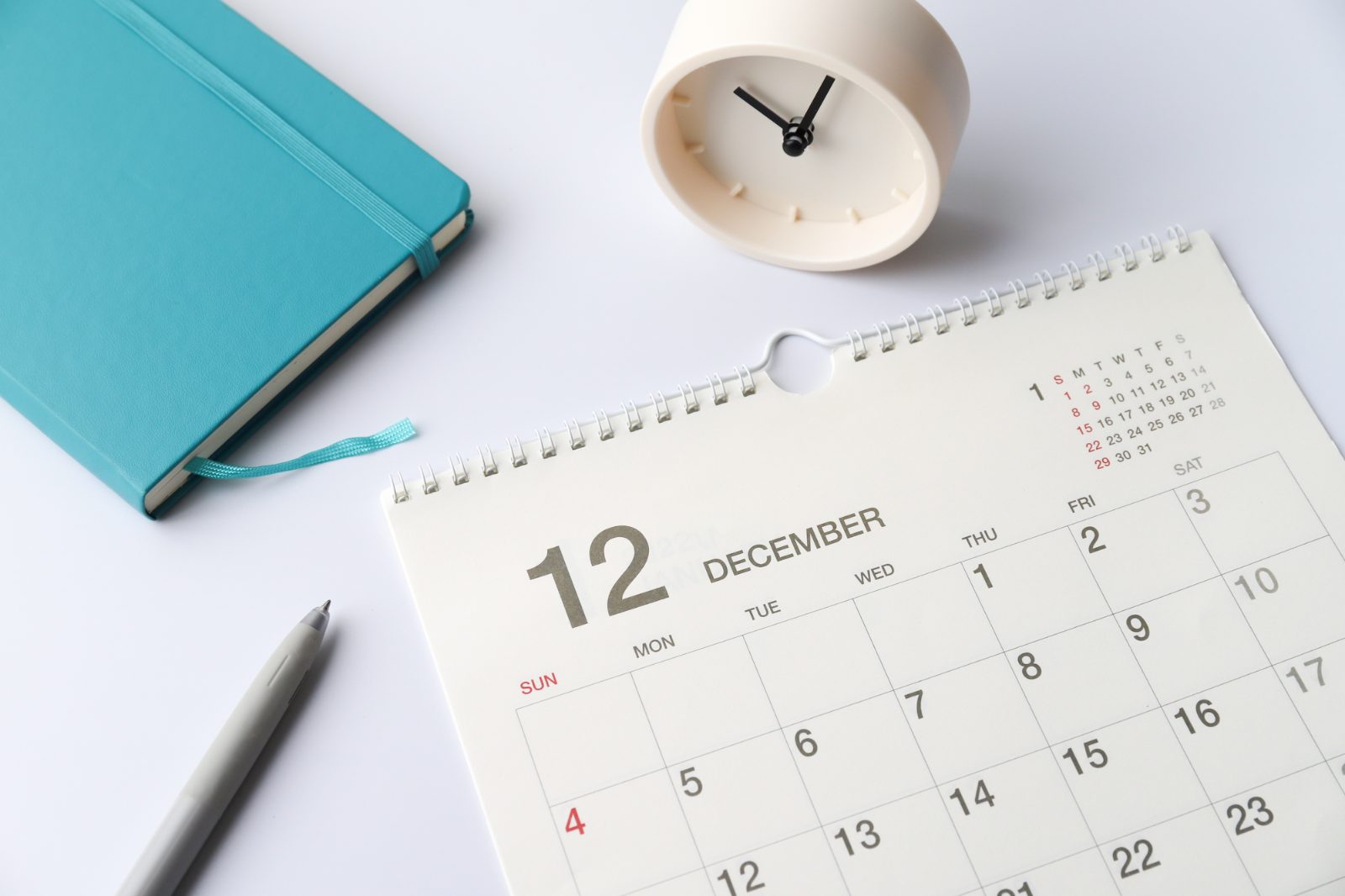 12月のカレンダーと置き時計。年末までの法人車両手配を逆算するスケジュールのイメージ